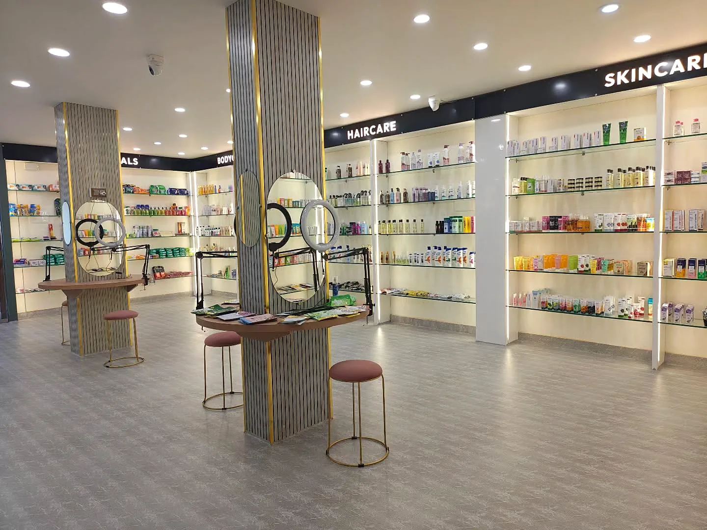 Mirror stations in front of the haircare and skincare walls, shown with ring-light brightness